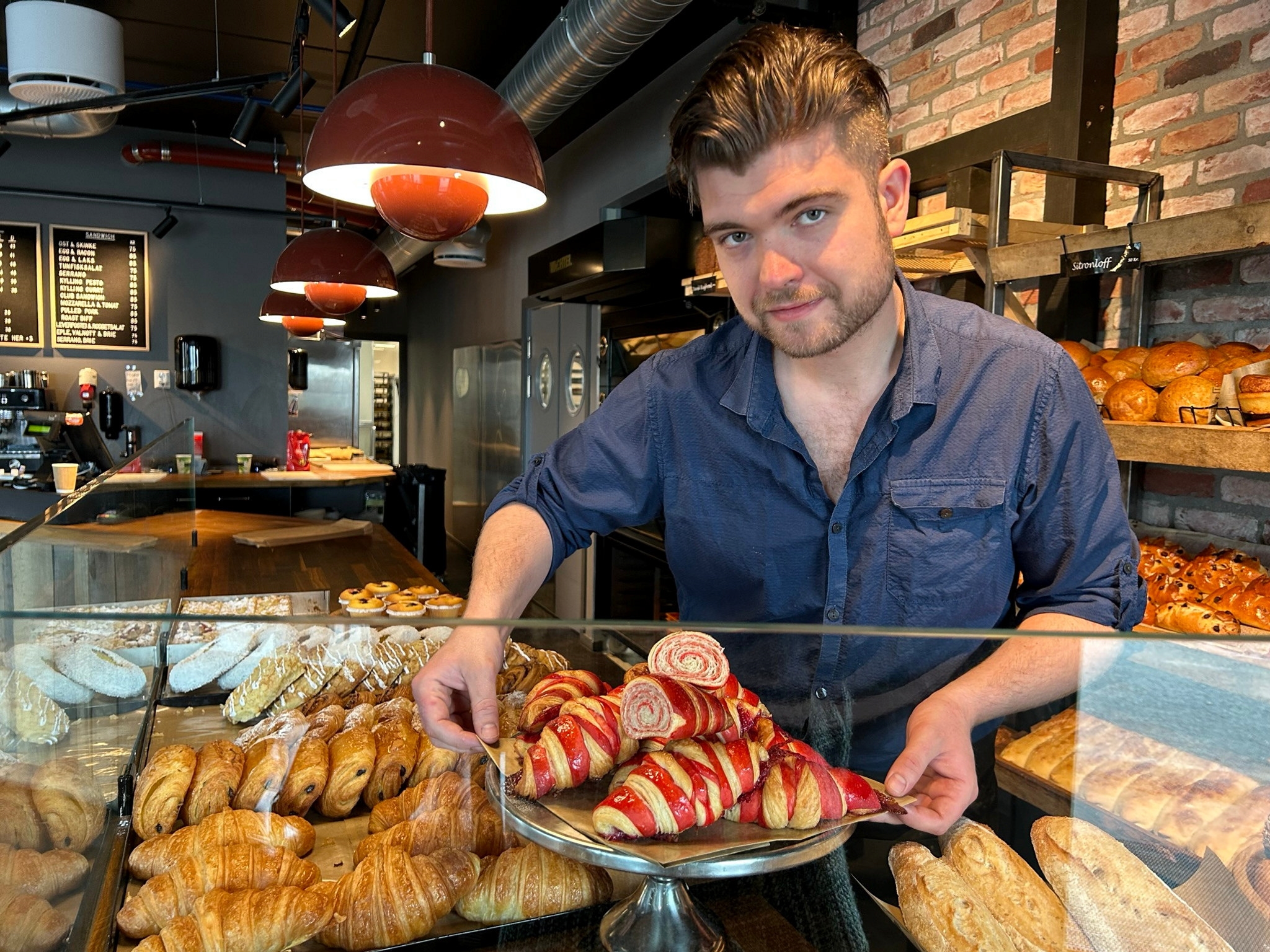 Salgsansvarlig viser frem nylanserte veganske bringebær-croissanter.